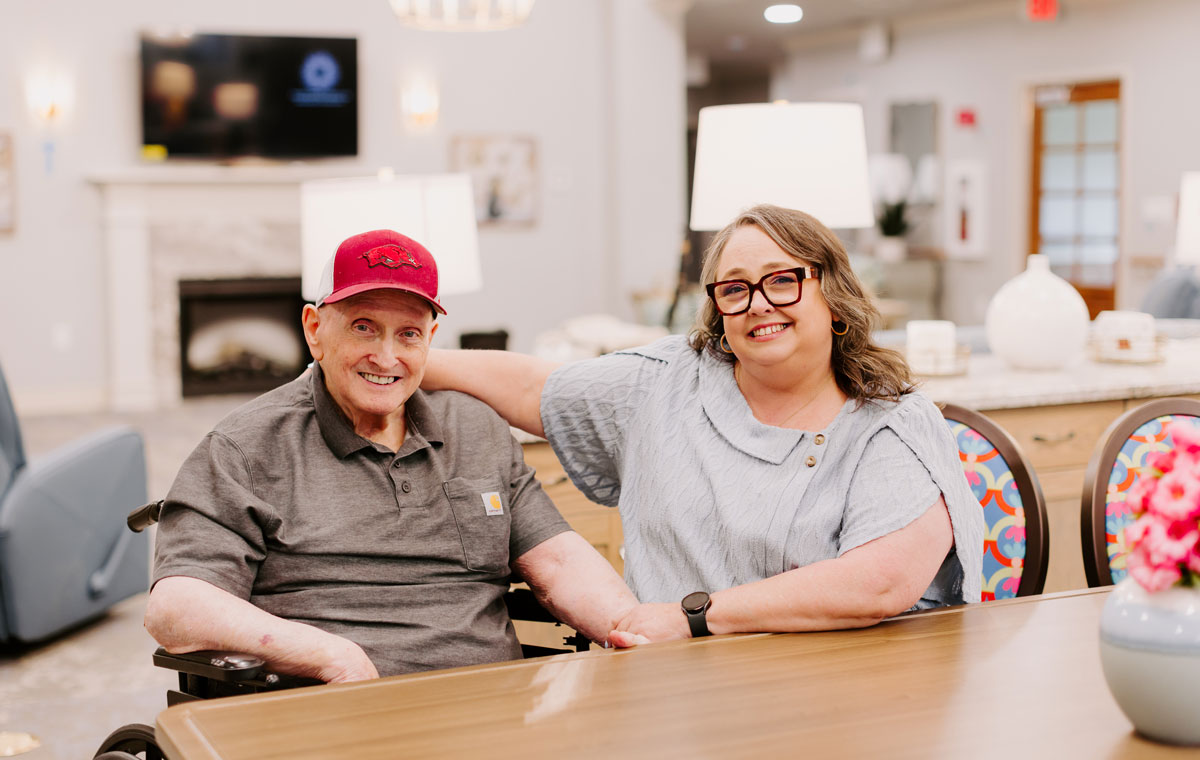 elderly man sitting at table with female caretaker